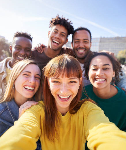 Group of happy friends posing for a selfie on a spring day as they party together outdoors. Group of multicultural friends having a good time together on the weekend.